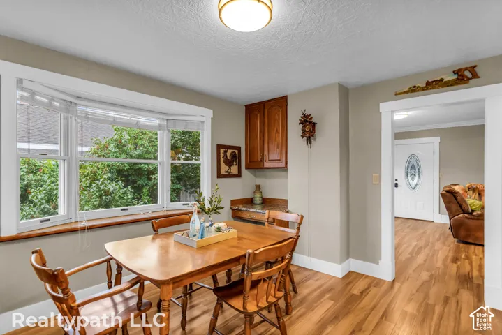 Dining area featuring a bay window, wood-finish flooring, and a built-in cabinetry with a countertop