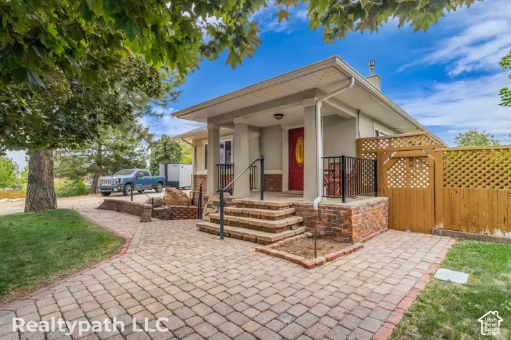 Front exterior with a covered porch, red entry door, and brick accents