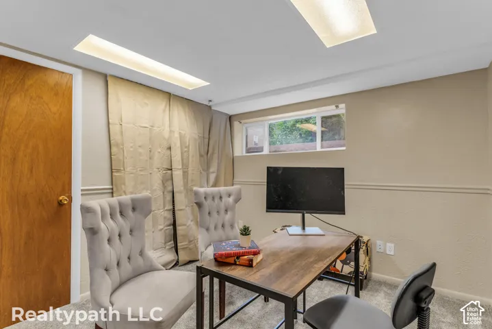 Room featuring recessed lighting, a wooden panel door, a window with outdoor views, and light-toned walls with chair rail molding