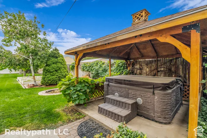 Backyard retreat featuring a gazebo-covered hot tub with composite steps