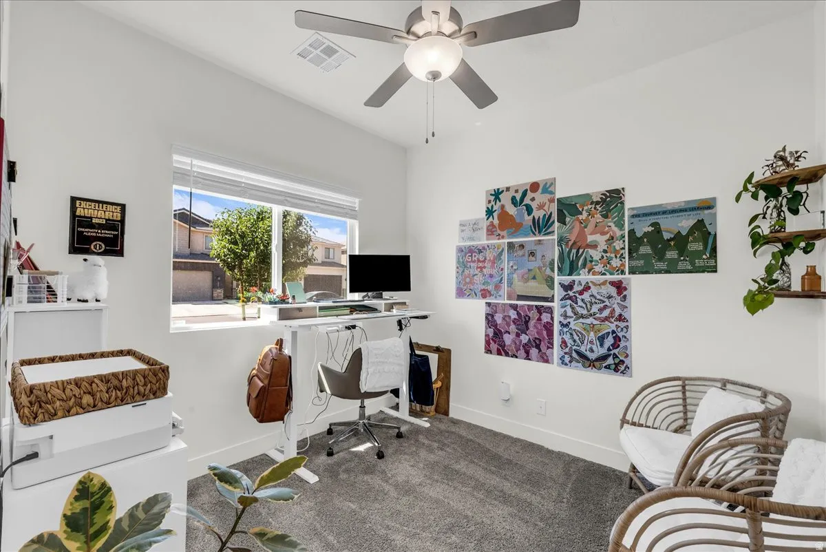 Bright room with a large window, neutral white walls, and gray carpet