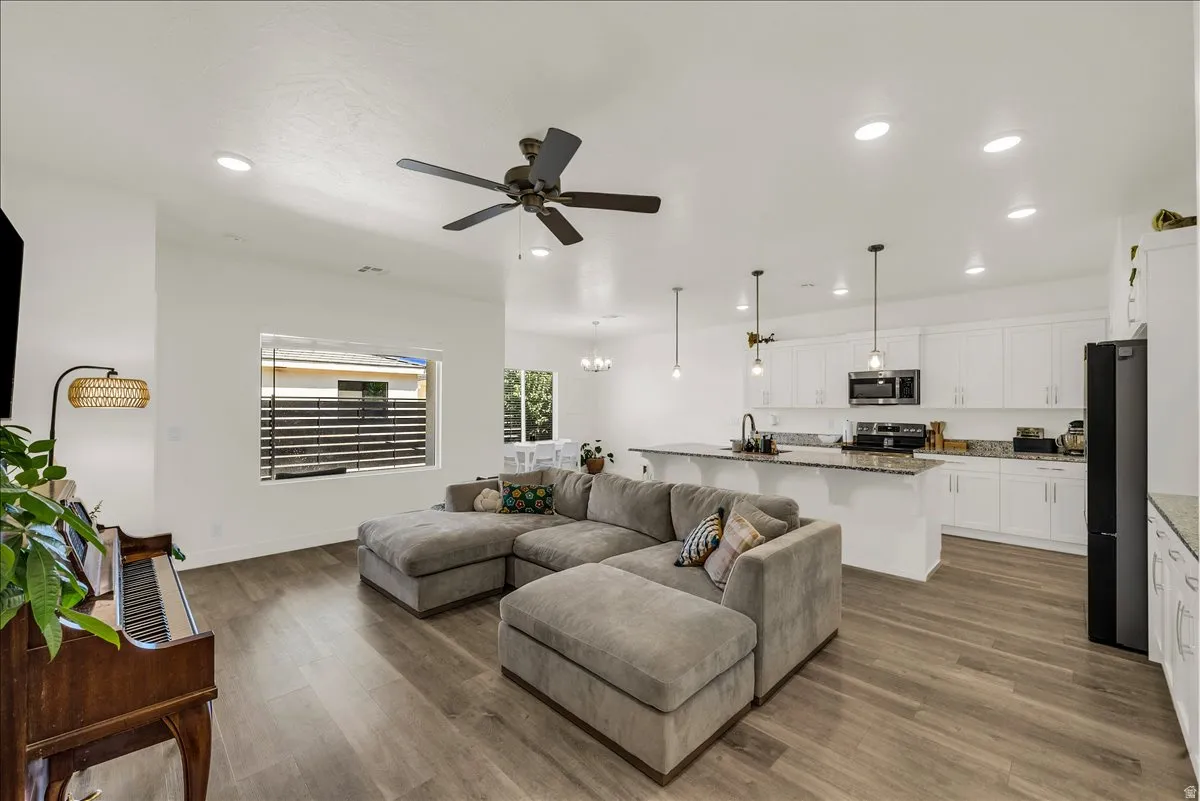 Open-concept living area featuring wood-finish flooring, recessed lighting, and a ceiling fan