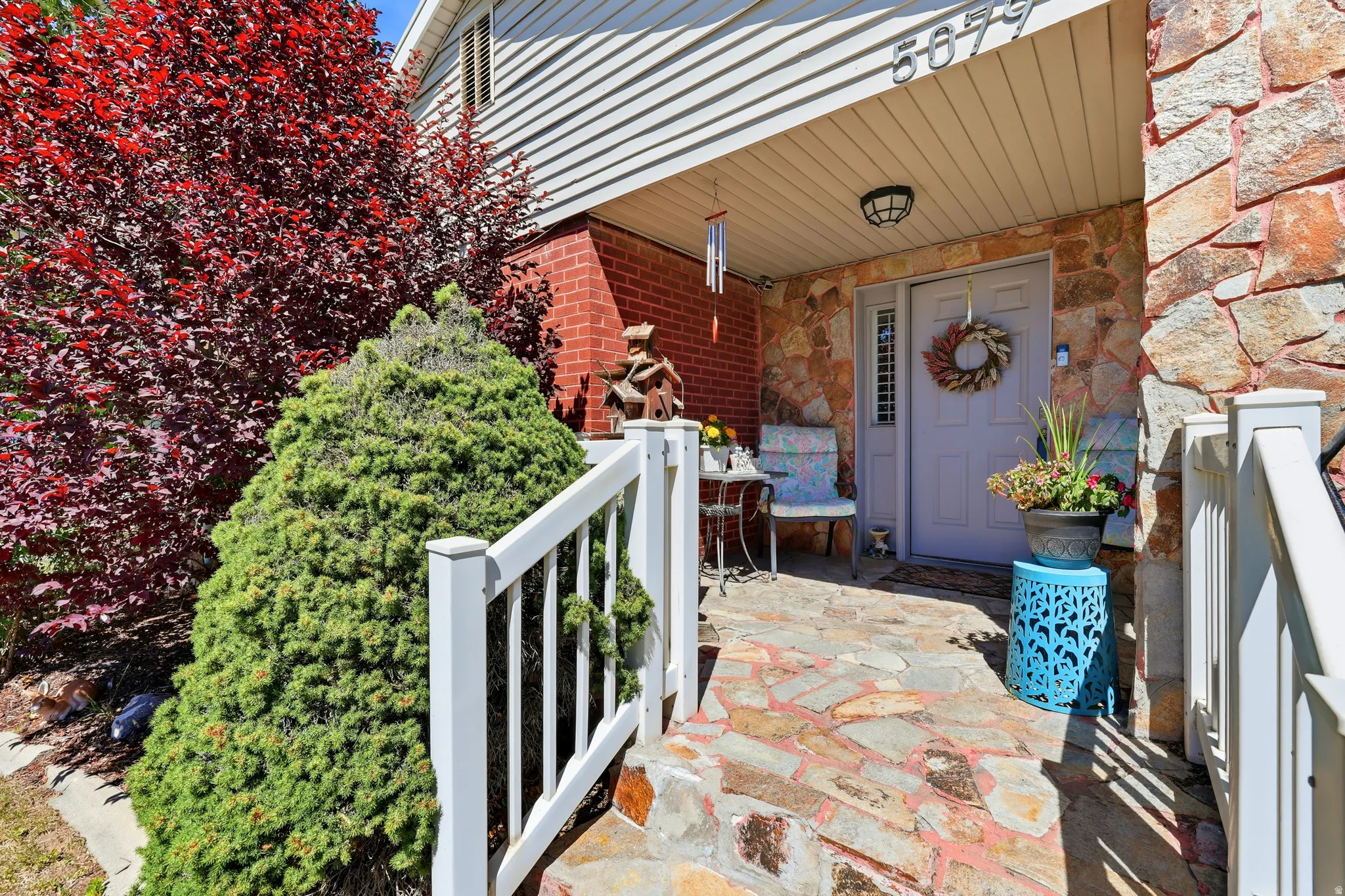 Inviting stone walkway leading to a covered entry with a light-colored door