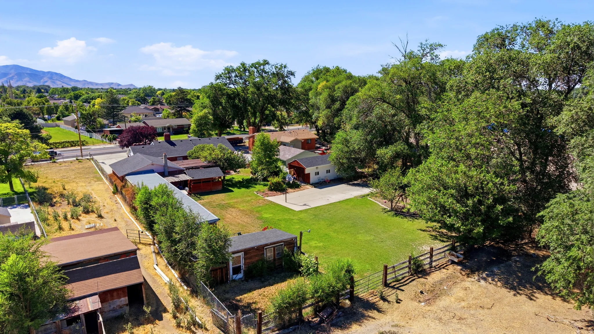 Expansive parcel featuring a large green lawn, mature trees, and a distant mountain backdrop