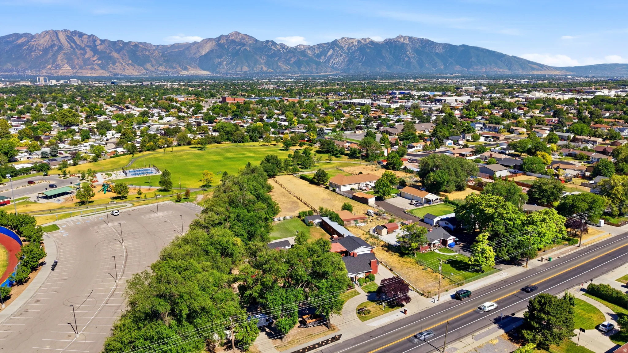 Aerial perspective showcasing a residential area with mature trees and a broad street
