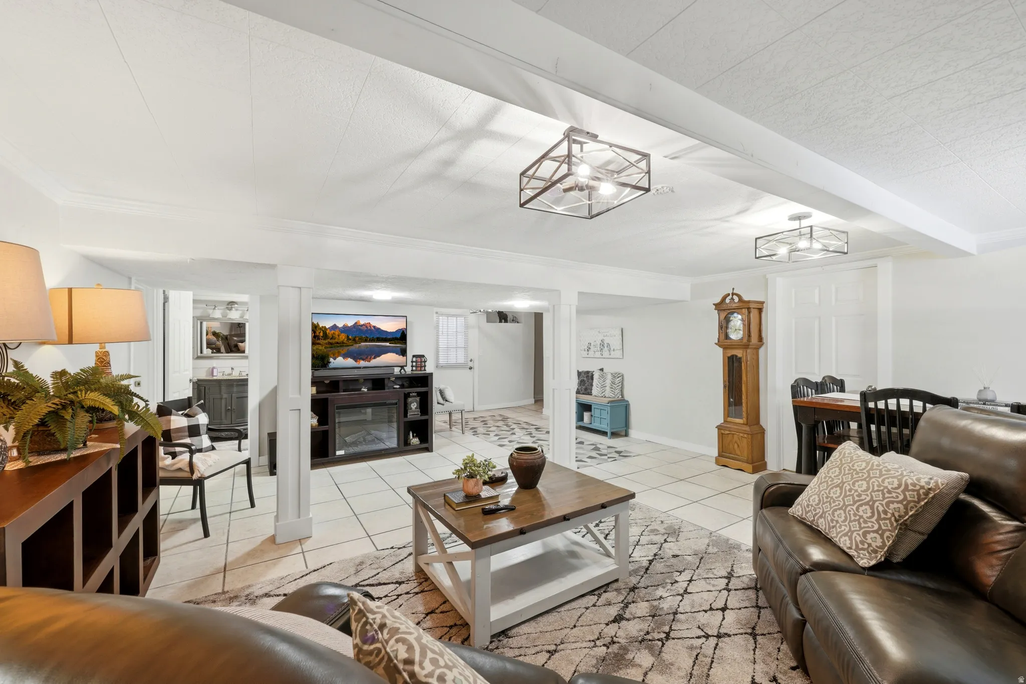 Open-concept living space with tile flooring, recessed lighting, and exposed ceiling beams