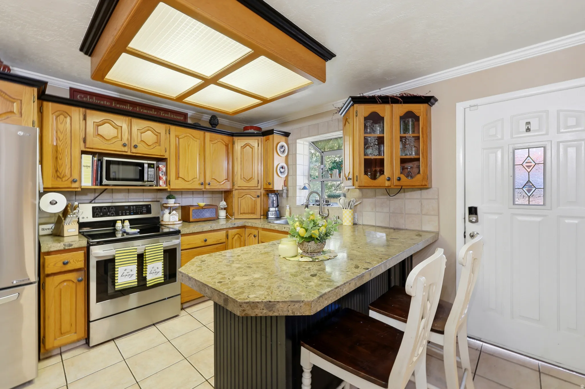 Kitchen featuring light-toned cabinetry, light-toned countertops, and stainless steel appliances