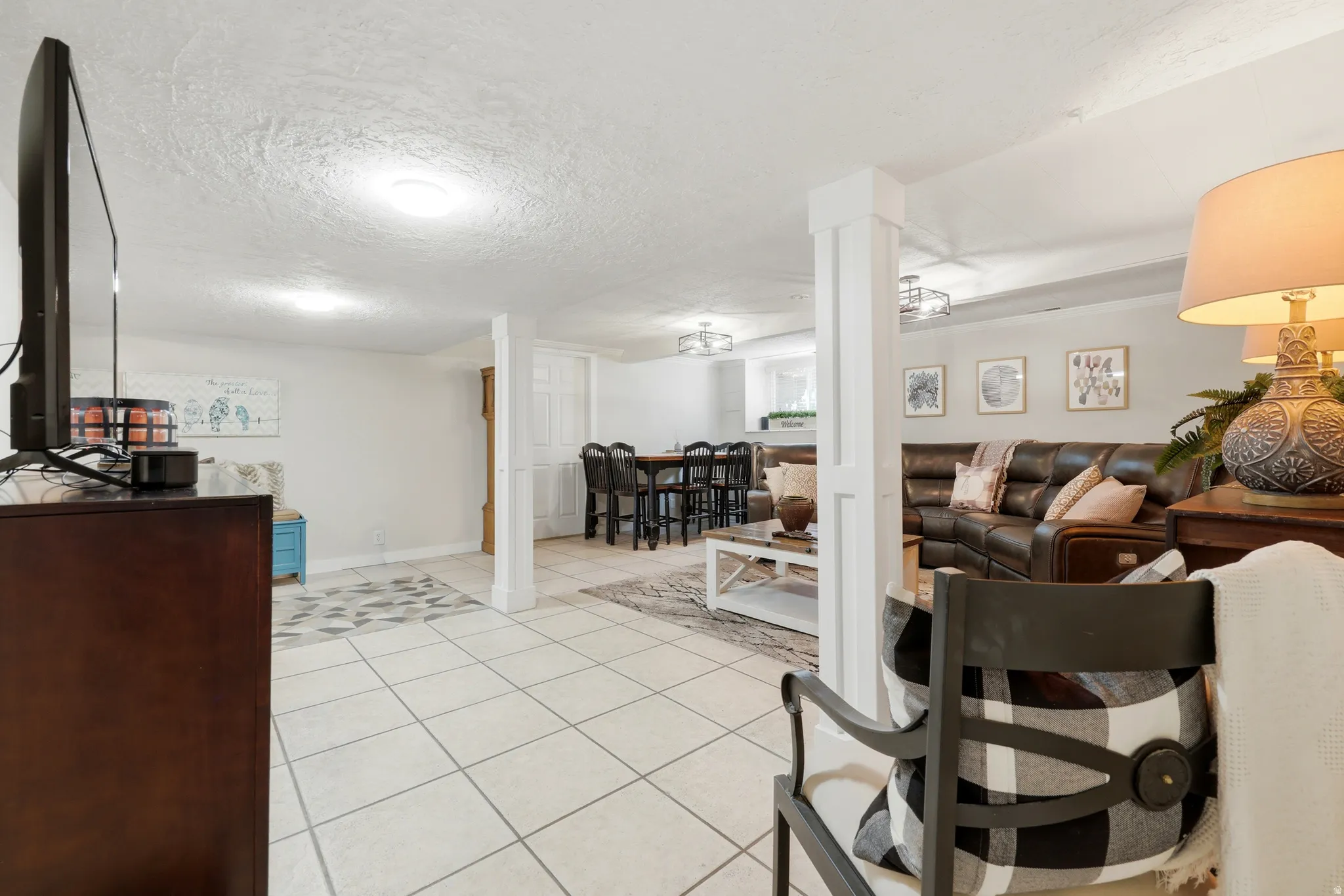 Spacious open-concept interior featuring light-toned tile flooring, recessed lighting, and white walls