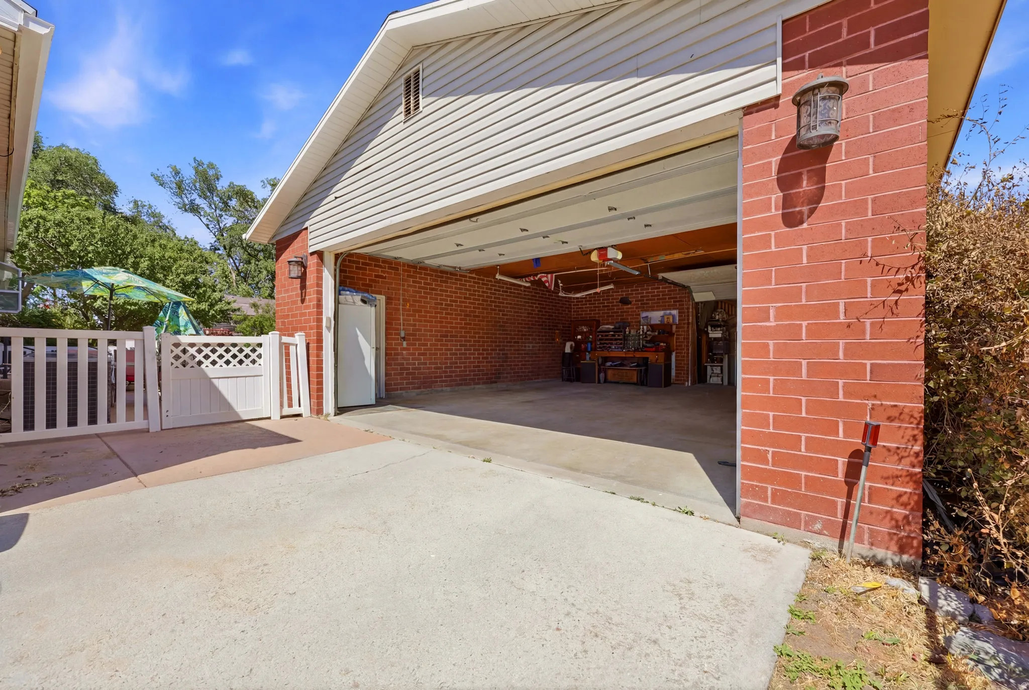 Spacious garage featuring a brick exterior, concrete flooring, and an overhead door