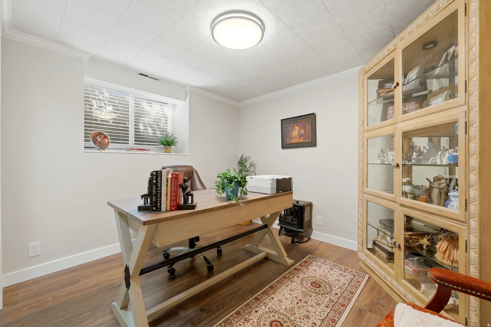Room featuring wood-finish flooring, a window with blinds, and white baseboards