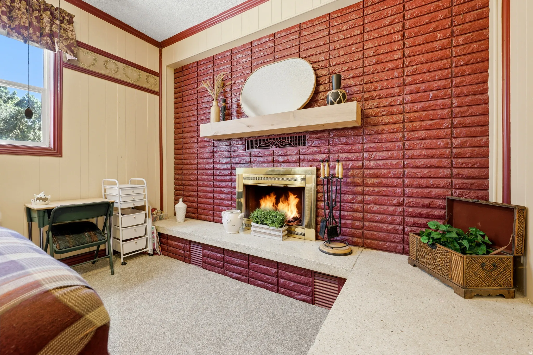 Brick fireplace with a brass firebox surround and a light-toned wood mantel