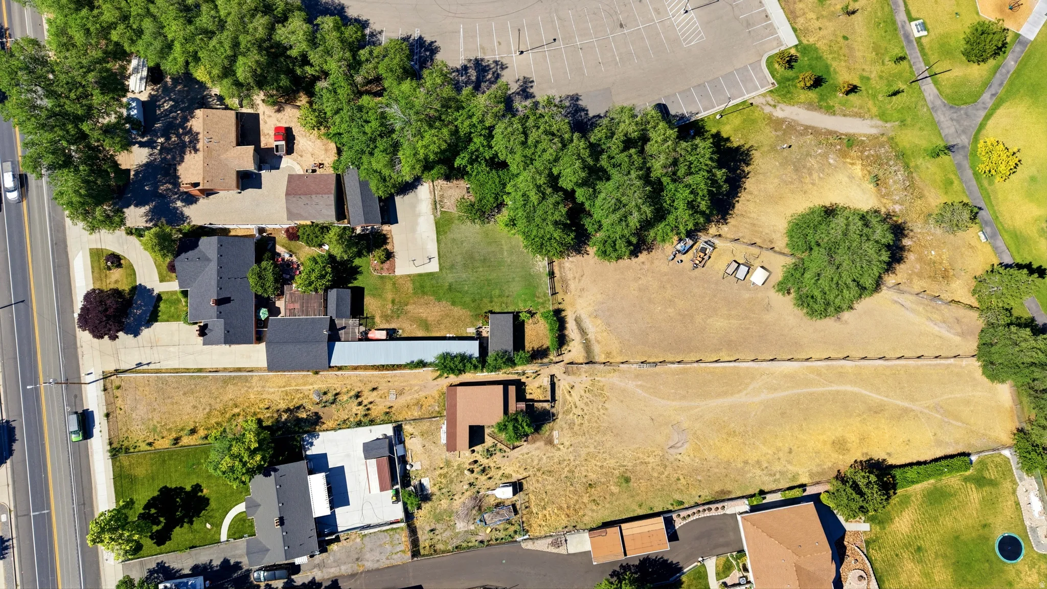 Expansive property featuring a substantial land parcel, mature trees, and direct road access