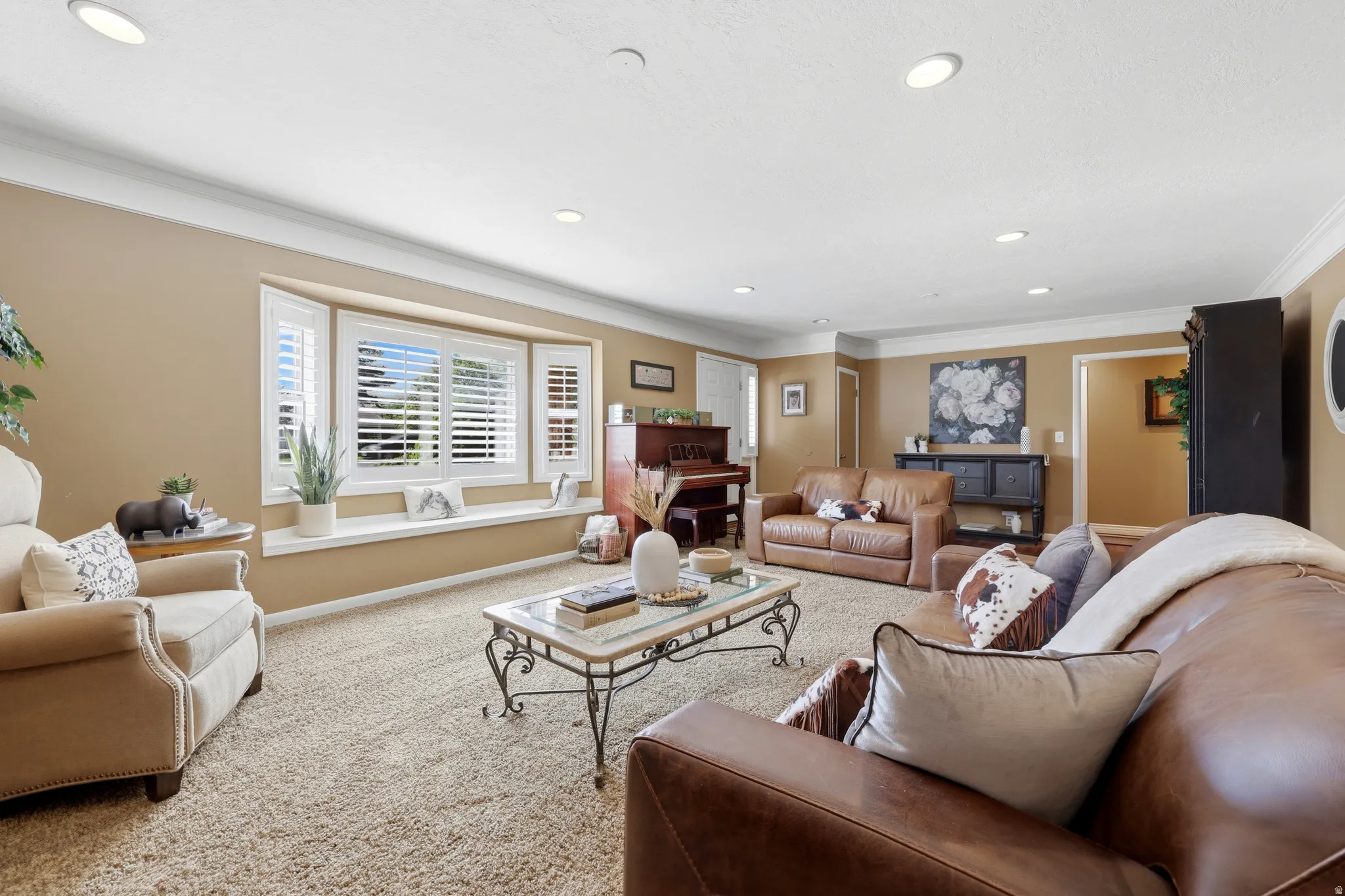 Spacious living area featuring a bay window with plantation shutters and a built-in window seat