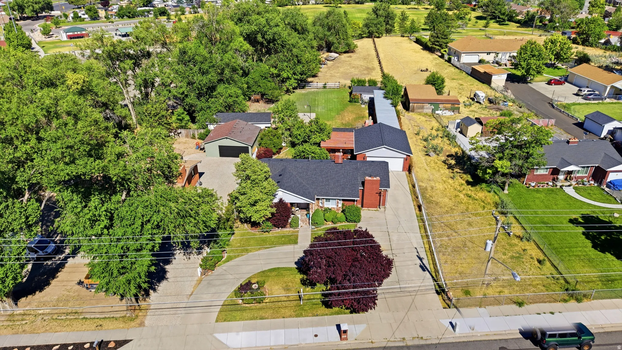 Aerial perspective showcasing a property with a brick exterior and a dark shingle roof
