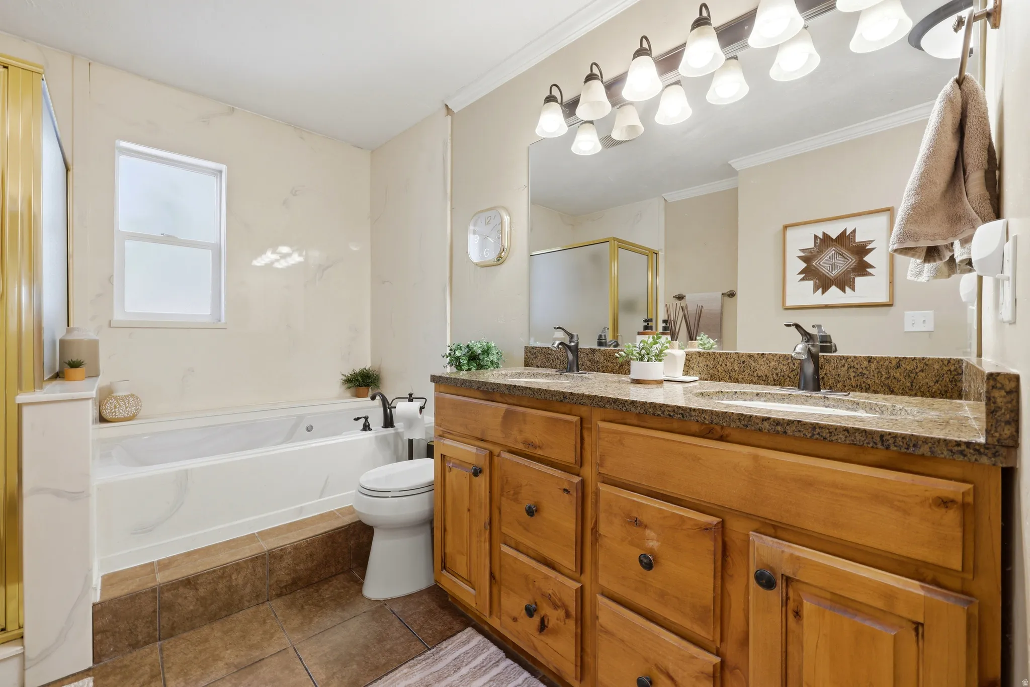 Double vanity with wood cabinetry and dark stone countertop