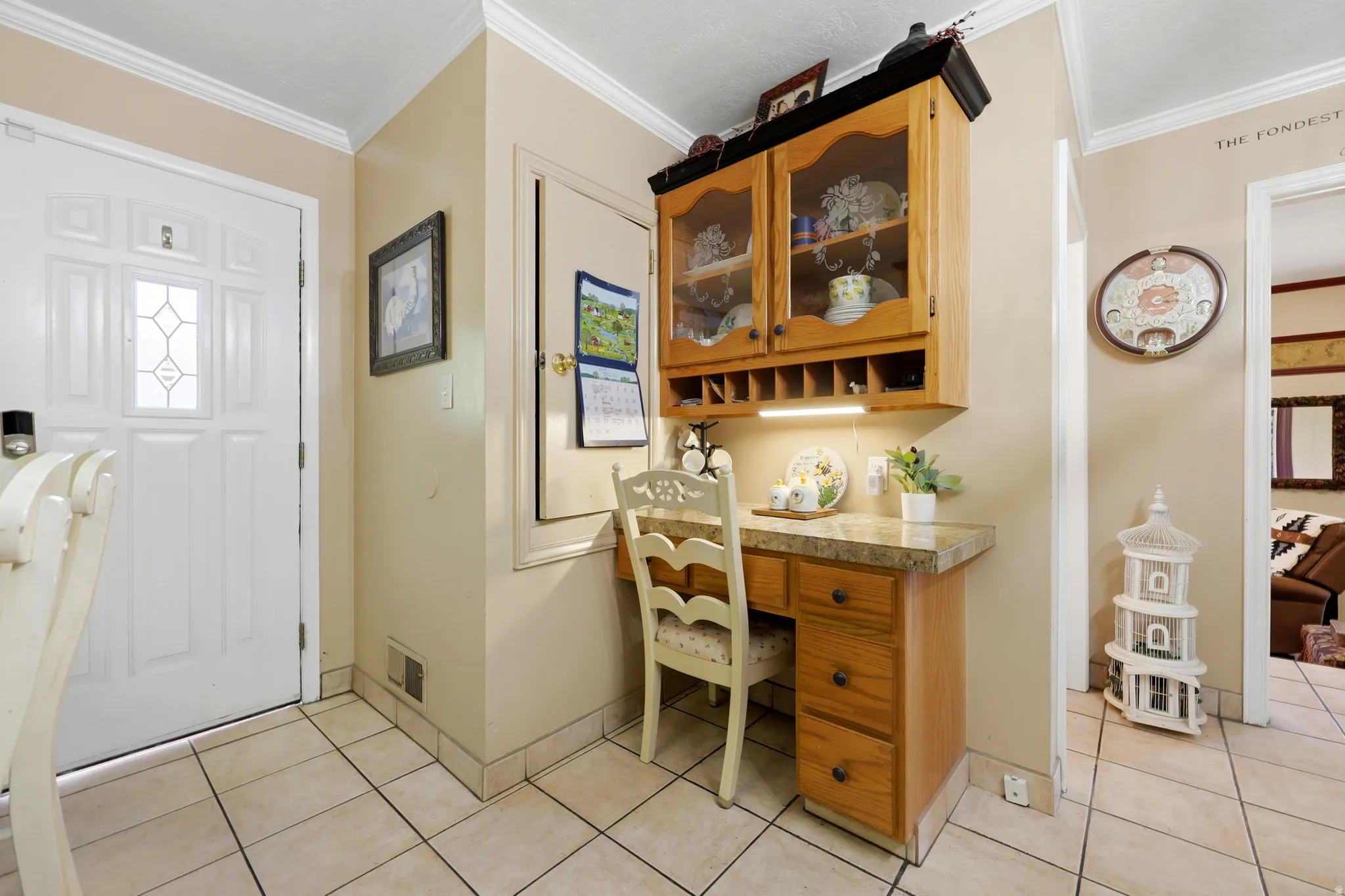 Built-in desk area featuring wood cabinetry, display shelving, and an integrated lighting fixture