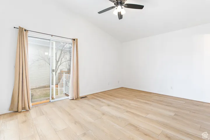 Spacious room featuring vaulted ceilings and light wood-finish flooring