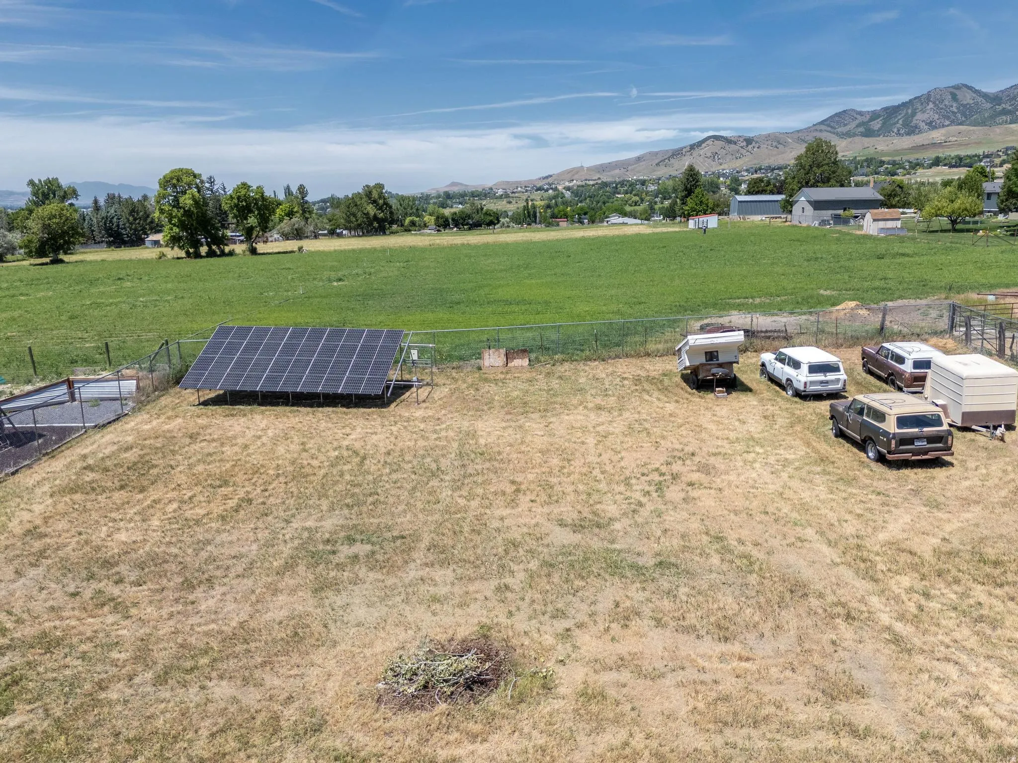 Ground-mounted solar panel array situated on a fenced portion of the property