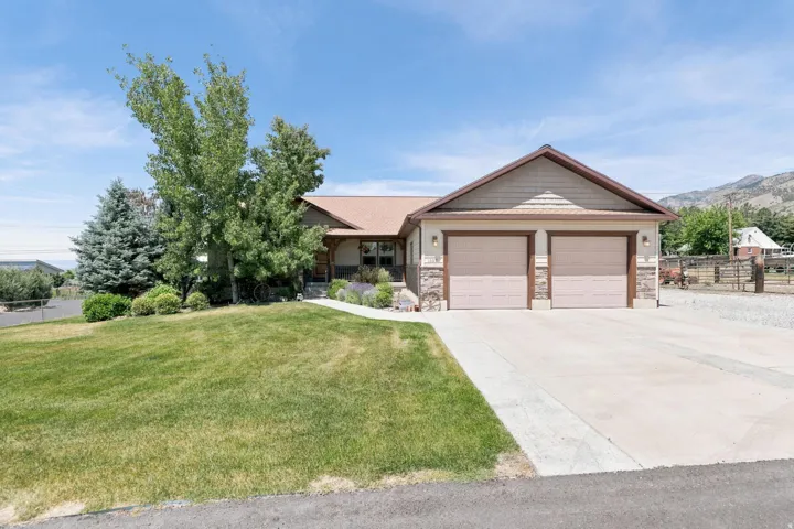 Exterior featuring a two-car garage, stone and siding facade, and a concrete driveway