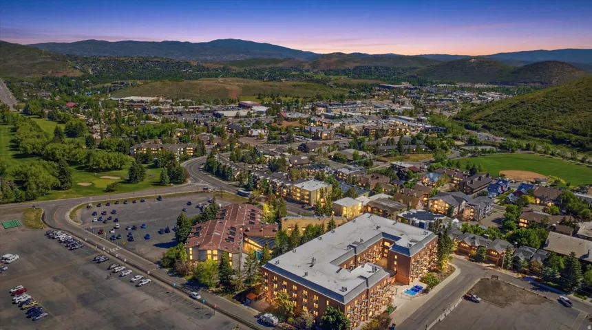 Expansive aerial view showcasing the central apartment building amidst a developed community