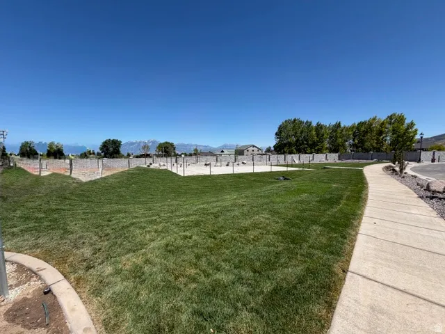 Expansive green lawn area with a concrete pathway