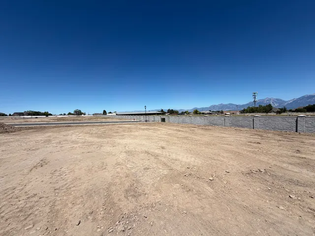 Expansive land parcel featuring a pre-graded surface and a perimeter retaining wall