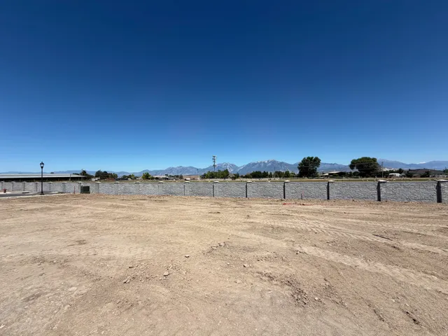 Expansive lot featuring a retaining wall, a street light fixture, and a mountain range backdrop