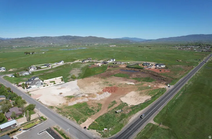 Expansive land parcel with surrounding green fields and distant mountains