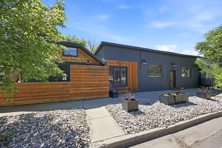 Contemporary exterior featuring dark-paneled siding and natural wood accents
