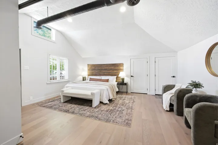 Vaulted ceilings featuring exposed ductwork and light wood-finish flooring