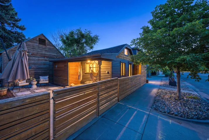 Contemporary exterior featuring horizontal wood siding and an inviting covered porch with a visible hammock