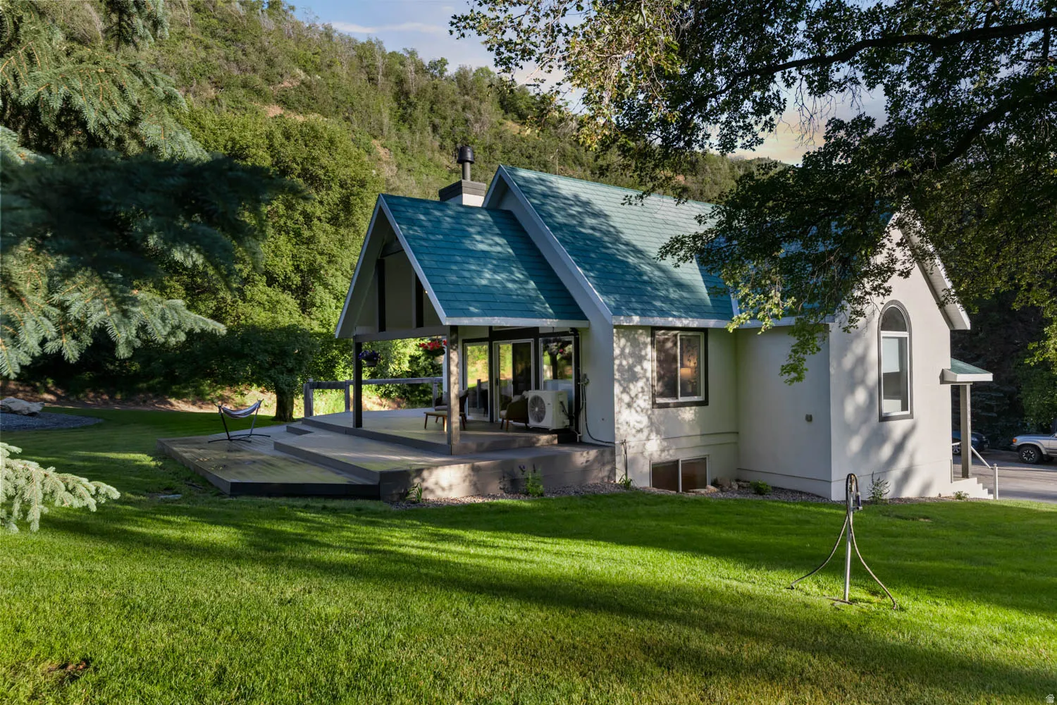 Contemporary stucco exterior with a distinctive teal shingle roof