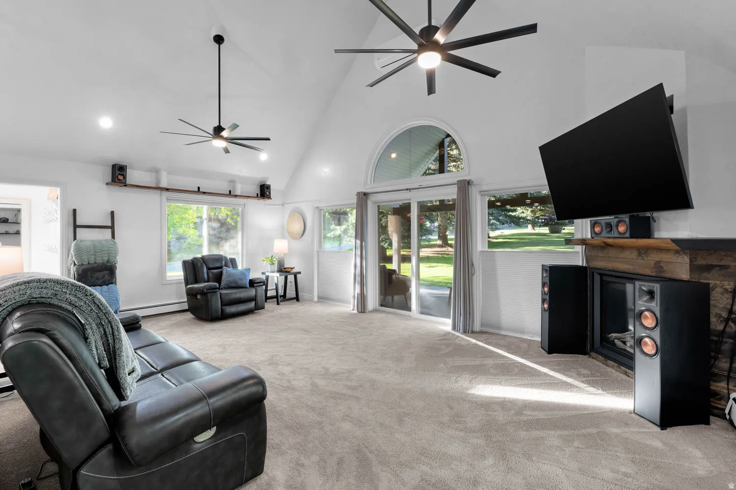 Living room featuring vaulted ceilings, recessed lighting, and a prominent fireplace with a wood mantel
