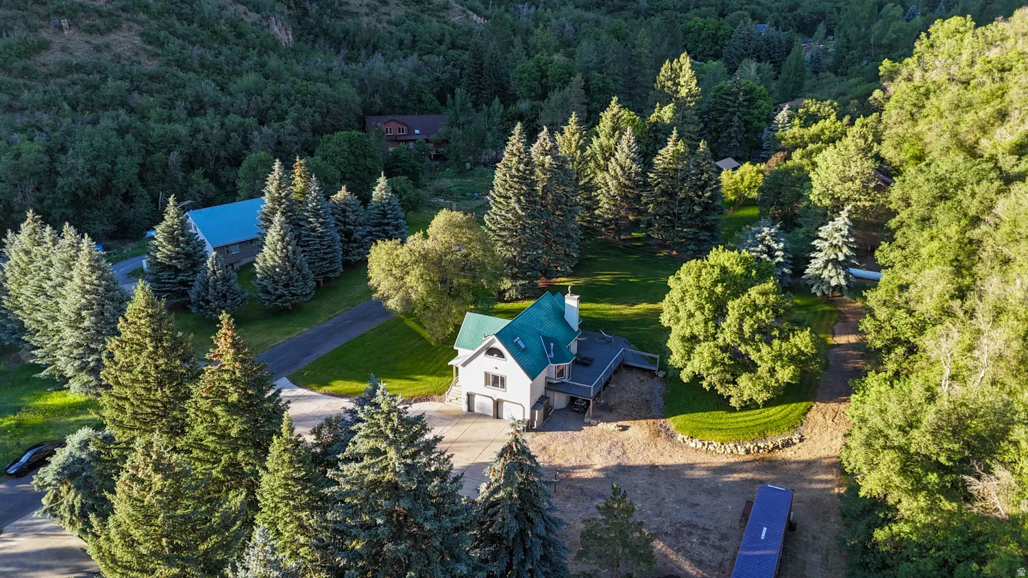 Expansive property featuring a residence with a green roof, two-car garage, and multiple outdoor decks