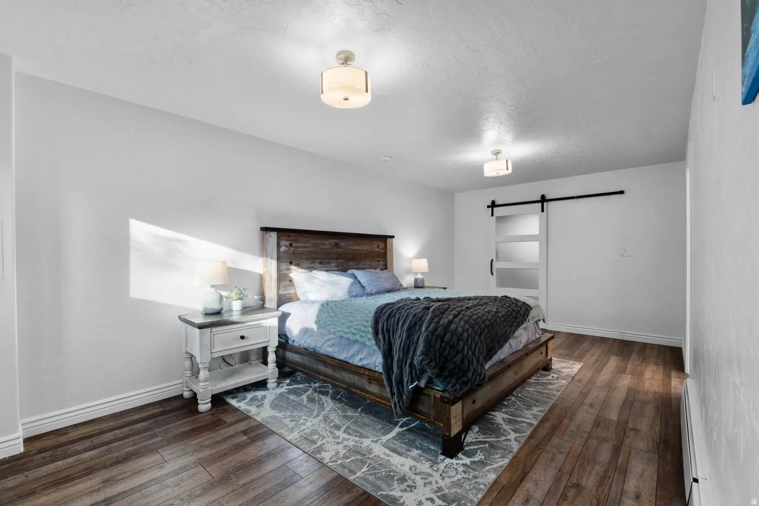 Bedroom with wood-finish flooring and white baseboards