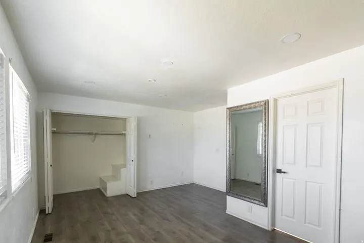 Room featuring wood-finish flooring, recessed lighting, and white walls