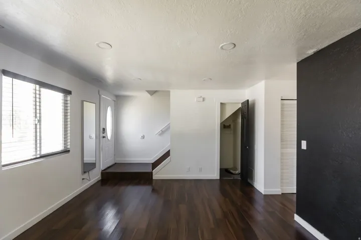 Spacious interior featuring rich wood-finish flooring, white walls, and recessed lighting