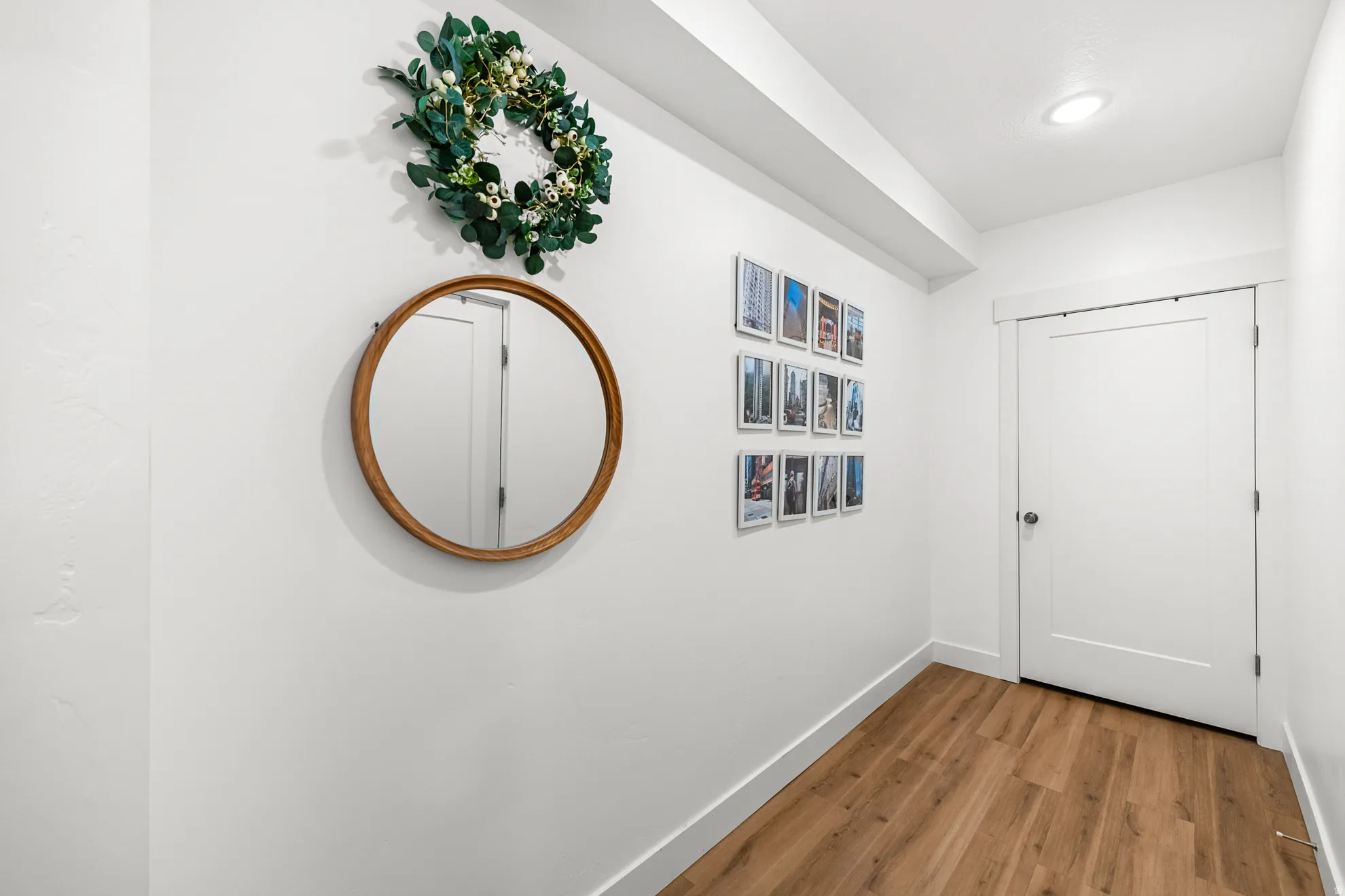 Hallway featuring wood-finish flooring, white walls, and recessed lighting