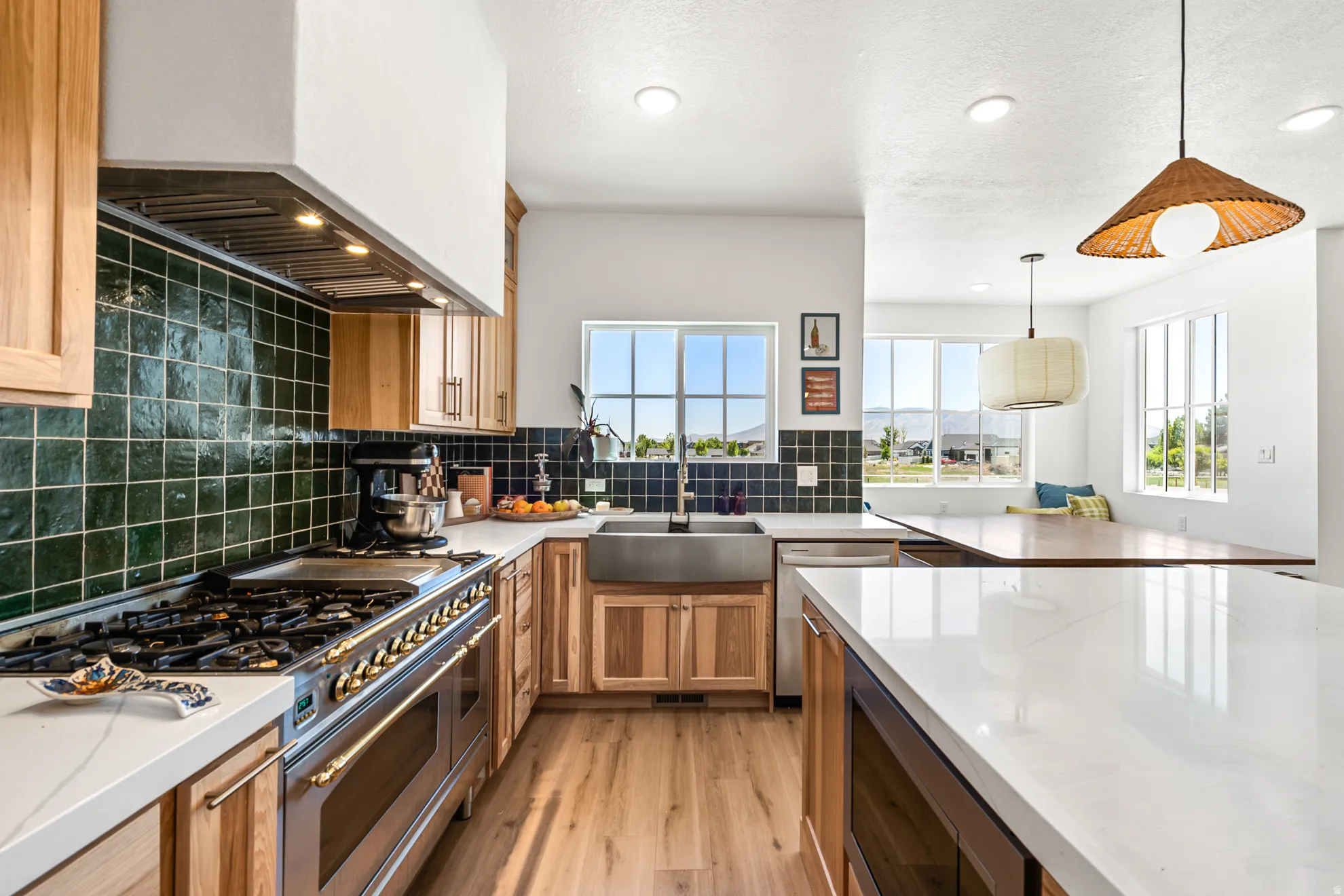 Open-concept kitchen with light wood cabinetry and white countertops