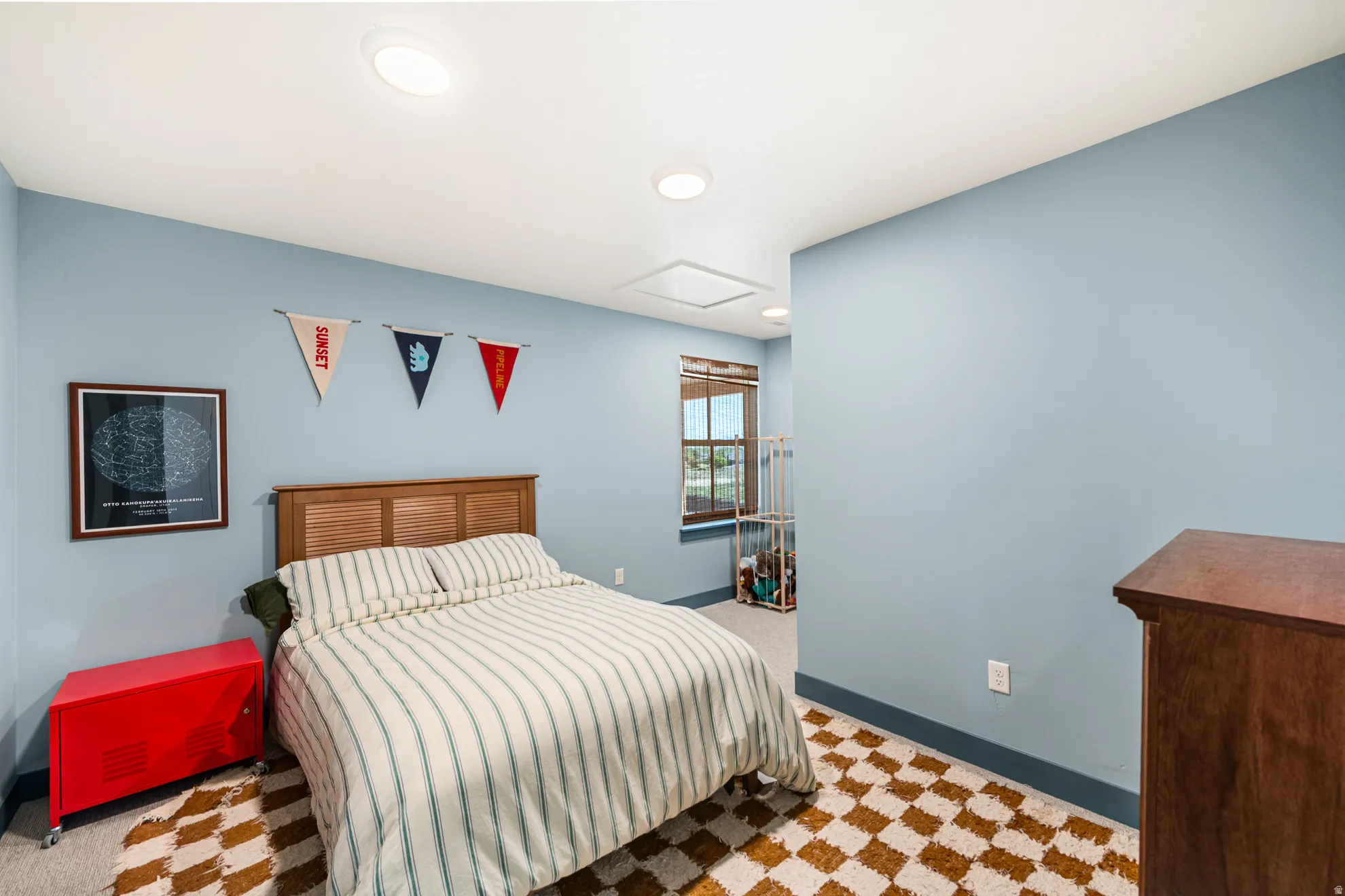 Recessed lighting illuminating light blue walls with a dark baseboard trim and carpet flooring