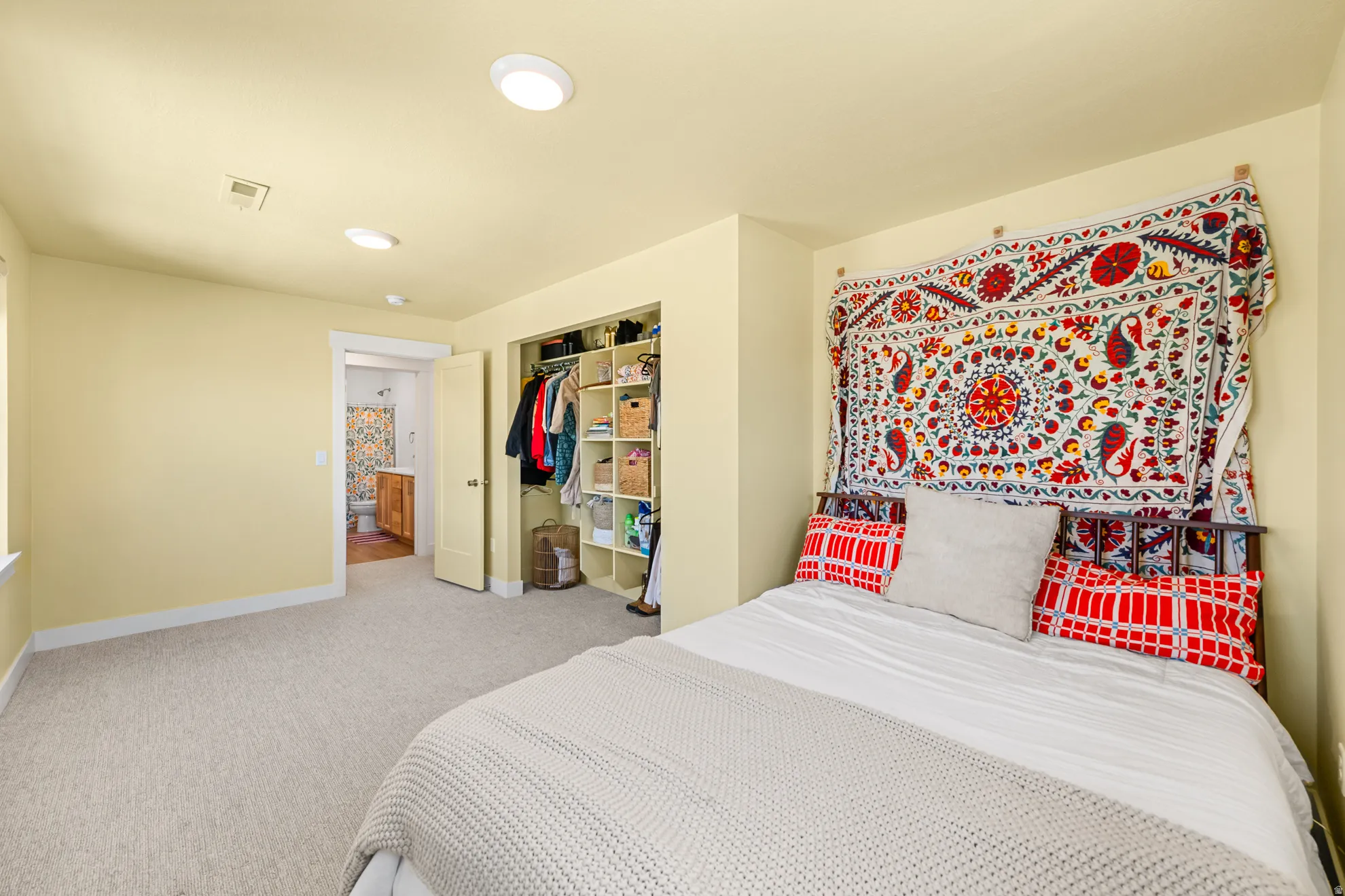 Carpeted bedroom featuring recessed lighting, a built-in closet with shelving, and a doorway to an additional room with wood-finish flooring