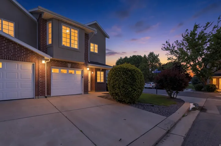 Brick and stucco exterior with multiple bay windows and white garage doors