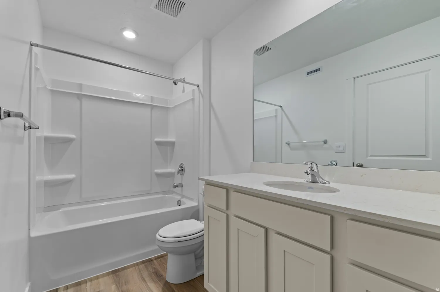 Full bathroom featuring a single vanity with stone-finish countertop, undermount sink, and chrome faucet