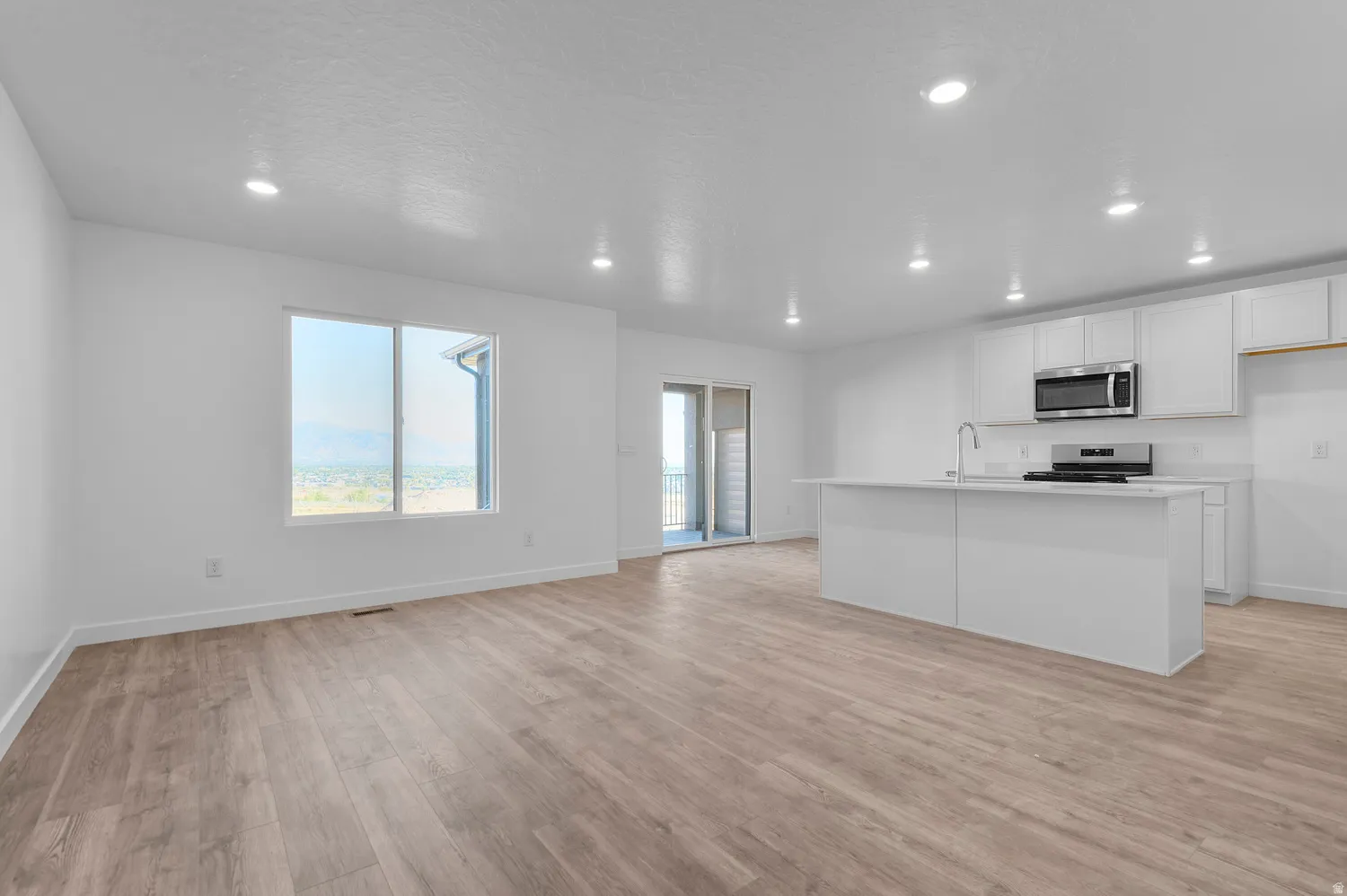 Expansive open-concept living area featuring wood-finish flooring and recessed lighting