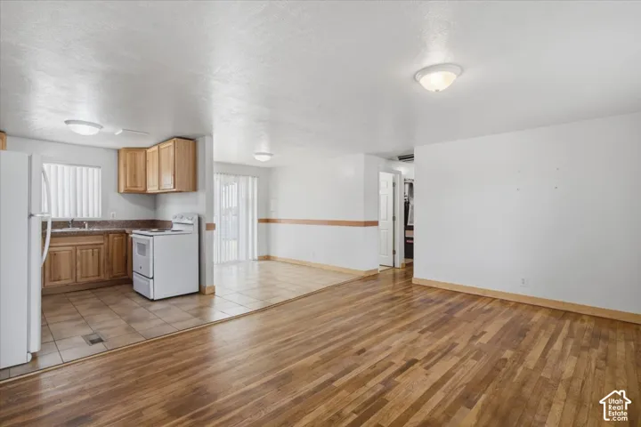 Kitchen with wood-finish cabinetry, tile flooring, and a white refrigerator