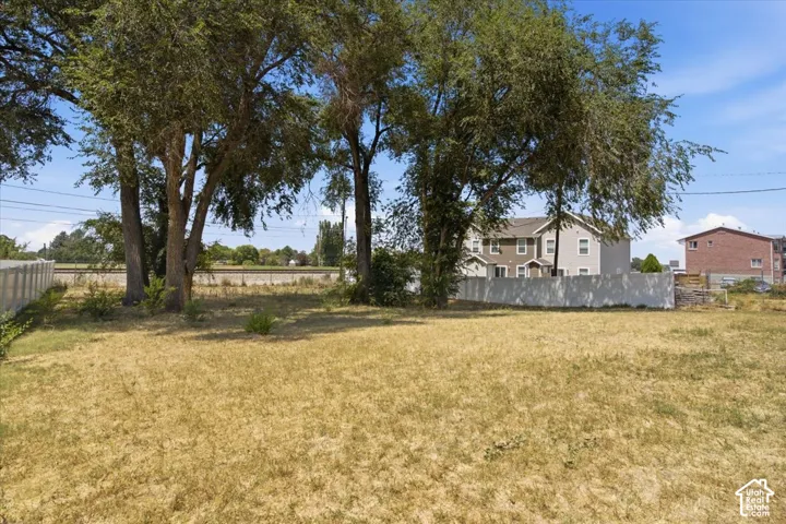 Expansive lot featuring mature trees and a concrete privacy fence