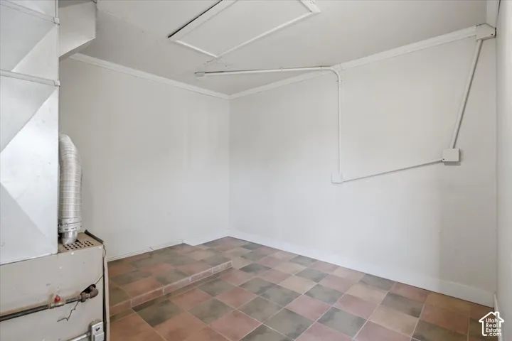 Utility area featuring checkerboard tile flooring and a built-in furnace