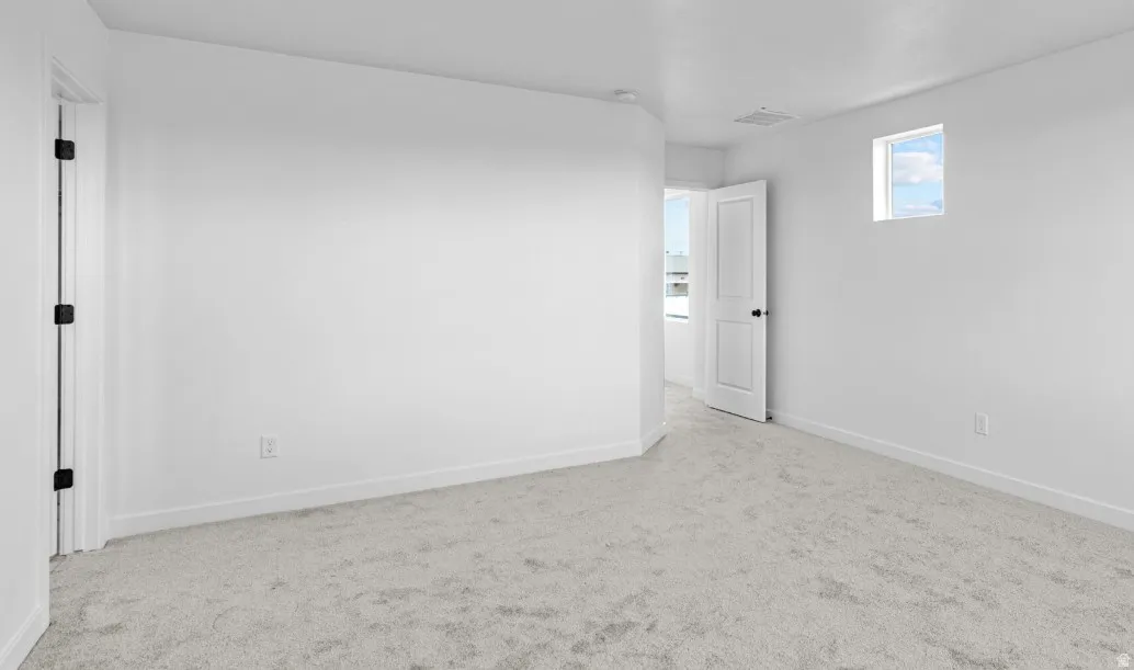 Carpeted room featuring a white interior door with black hardware, a high window, and neutral wall tones
