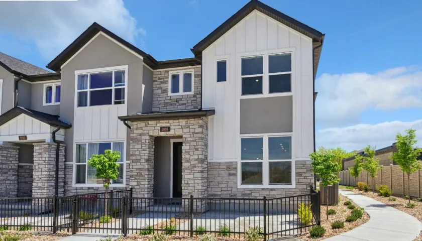 Contemporary townhouse exterior featuring a multi-textured facade with stone, stucco, and vertical siding
