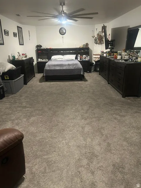 Spacious room featuring neutral carpeting and a ceiling fan